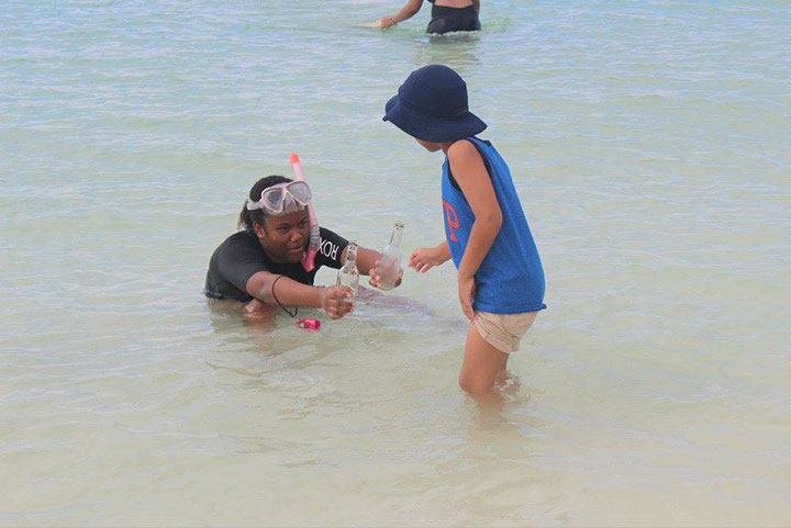 Angelina-Rahming_-EARTHCARE-Eco-Kids-Team-Leader_-hands-----beverage-bottles-found-underwater-to-her-brother_-Aiden-for-proper----disposal--onsh.jpg