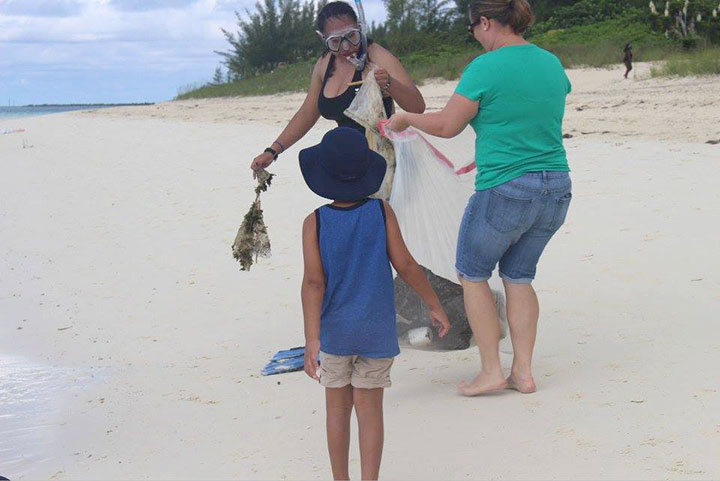 Candice-Woon-hands-marine-debris-to-Linda-----Gembalies-Rahming-as-her-son_-Aiden-Rahming-looks-on.jpg