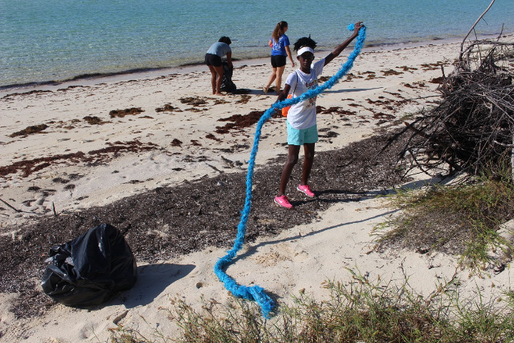 EARTHCARE_volunteer__Ms._Gibson_______________from_BMES_holds_up_a_discarded_rope_during_International___Coastal_________Cleanup_____Day.jpg