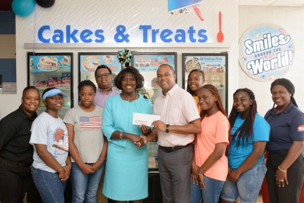 _reduced__Derek_Osborne_Presenting_Cheque_to_Principal_Sonja_Rolle_and_students_1_.jpg